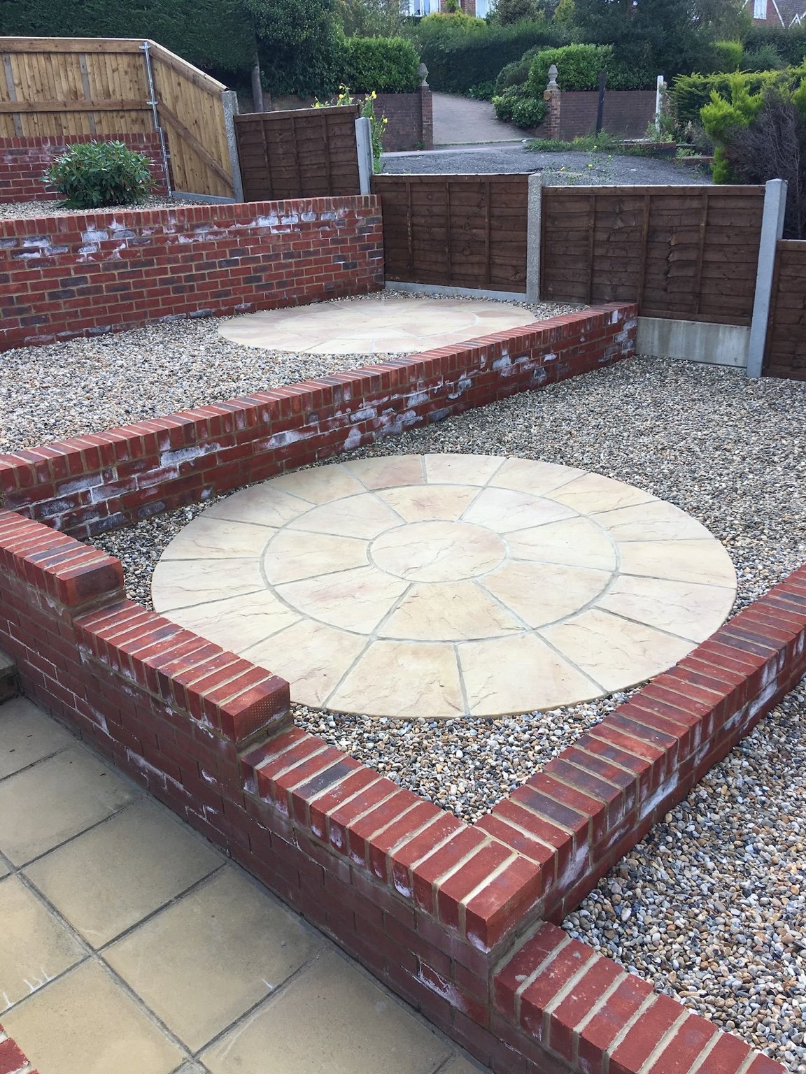Canterbury tiered garden with brick walls, shingle and buff paving circles
