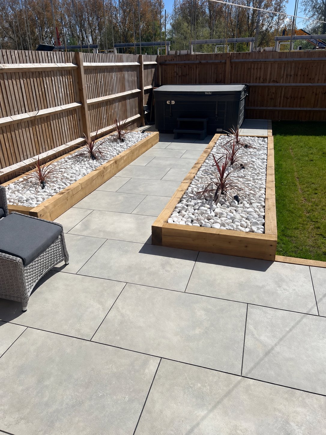 Strood porcelain patio with timber sleeper planters